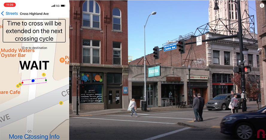  A man using a cane crosses enters a crosswalk with another man in an urban environment, while a sidebar to the image shows that time has been extended in the walk signal.